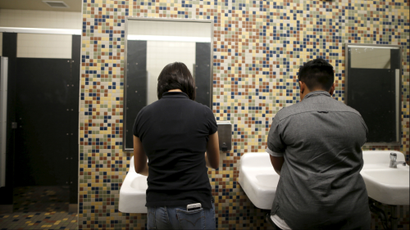 Two people washing their hands in a bathroom.