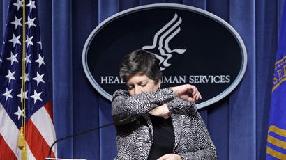 Homeland Security Secretary Janet Napolitano shows the proper way to sneeze as Health and Human Services Secretary Kathleen Sebelius looks on at right