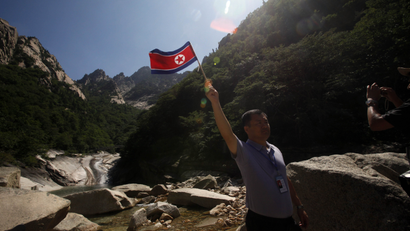 A Chinese tourist poses with a North Korean flag as he visits Mount Kumgang in North Korea, Wednesday, Aug. 31, 2011. Since South Korean tourists have been barred from the luxury resort, known abroad as Diamond Mountain, North Korea has begun courting Chinese and other international tourists. (AP Photo/Ng Han Guan)