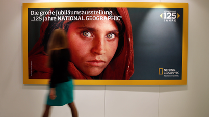 A woman walks by a poster advertising the exhibition '125 Jahre National Geographic' (lit.: 125 Years National Geographic) at the Gruner und Jahr publishing house in Hamburg, Germany, 12 September 2013. National Geographic Germany presents a selection of photographs from the 125 year history of the magazine from 14 September to 13 October.