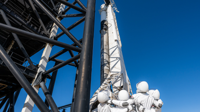 The Inspiration4 astronauts look up at the SpaceX Falcon 9 rocket and Dragon capsule that will carry them to space.