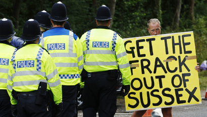 A demonstrator stands in the road as police escort a lorry to a site run by Cuadrilla Resources, outside the village of Balcombe in southern England.