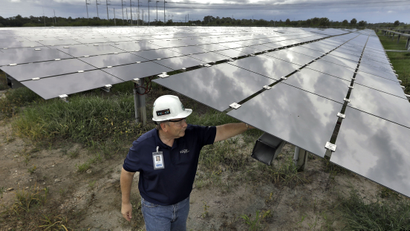 Guy Morris, project manager for the Tampa Electric Company's Big Bend Solar Station, adjusts some of the solar panels Friday, June 2, 2017, in Gibsonton, Fla. The panels at the station will power about 3,000 homes in the area. (AP Photo/Chris O'Meara)