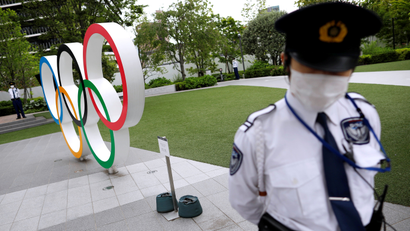 Security personnel stand guard near the Olympic rings monument during a rally by anti-Olympics protesters outside the Japanese Olympic Committee headquarters, amid the coronavirus disease (COVID-19) outbreak, in Tokyo, Japan May 18, 2021. REUTERS/Issei Kato