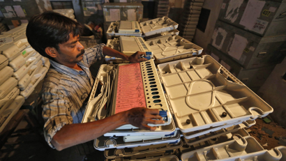 An image of a member of election duty staff arranging an EVM inside a strong room