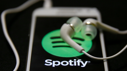 Earphones are seen on top of a smart phone with a Spotify logo on it, in Zenica February 20, 2014. Online music streaming service Spotify is recruiting a U.S. financial reporting specialist, adding to speculation that the Swedish start-up is preparing for a share listing, which one banker said could value the firm at as much as $8 billion (4 billion pounds). REUTERS/Dado Ruvic (BOSNIA AND HERZEGOVINA - Tags: SCIENCE TECHNOLOGY BUSINESS SOCIETY) - RTX1971J