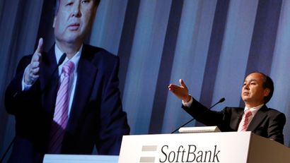 Softbank Corp CEO Masayoshi Son gestures towards a reporter during a news conference in Tokyo February 12, 2014. SoftBank Corp, which runs Japan's third-largest mobile carrier by subscriber numbers, reported a dip in third-quarter net profit after a string of acquisitions incurred steep integration costs.