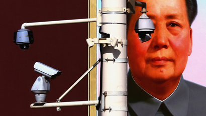 Security cameras attached to pole in front of a portrait of former Chairman Mao at Beijing's Tiananmen Square