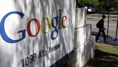 In this June 5, 2014 photo, a man walks past a Google sign at the company's headquarters in Mountain View, Calif. Google is buying Skybox Imaging in a deal that could serve as a launching pad for the Internet company to send its own fleet of satellites to take aerial pictures and provide online access to remote areas of the world. (AP Photo/Marcio Jose Sanchez)