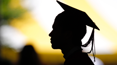 Silhouette in profile of a student wearing graduation cap and gown