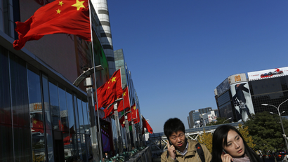 Chinese people talk on mobile phones outside a shopping mall in Beijing, China, Tuesday, Nov. 13, 2012. (AP Photo/Vincent Yu)