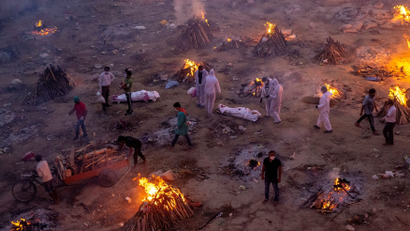 People wait to cremate COVID-19 victims at a crematorium ground in New Delhi