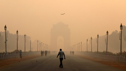 A man walks in front of the India Gate shrouded in smog in New Delhi