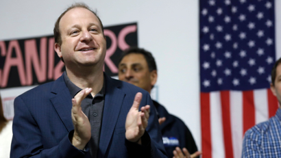 Jared Polis, left, Democratic candidate for Colorado's governorship, and Jason Crow, Democratic candidate for the U.S. House seat in District 6, applaud for canvassers before they set out to talk to voters Saturday, Nov. 3, 2018, in north Denver.