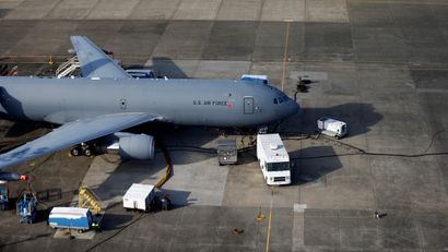 A KC-46A Pegasus on the ground with vehicles around it.