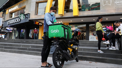 Grab delivery worker outside a McDonald's restaurant in Malaysia.