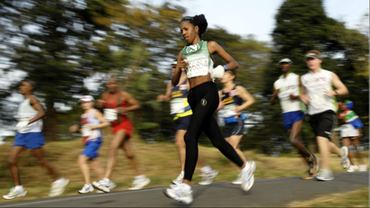 Runners in an ultra marathon; one woman is in focus, the rest blurred behind her.
