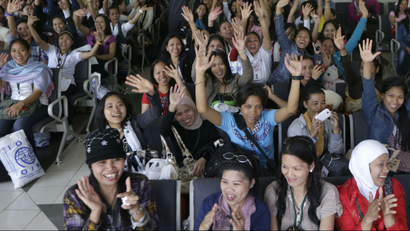 Overseas Filipino Workers, who fled the civil war in Syria, cheer upon arriving at the Ninoy Aquino International Airport via a chartered flight by the International Organization for Migration on Tuesday, Sept. 11, 2012, in Manila, Philippines. The nearly 300 workers, all of them young women who worked as babysitters and maids in Syria, said they were scared for their safety and sought shelter at the Philippine Embassy in Damascus until their repatriation Tuesday. (AP Photo/Bullit Marquez