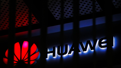FILE - In this March 8, 2019, file photo, A logo of Huawei retail shop is seen through a handrail inside a commercial office building in Beijing. Chinese tech giant Huawei’s tensions with Washington, which accuses the telecom equipment maker of being a security risk, stretch across four continents from courtrooms to corporate boardrooms to Canadian canola farms. (AP Photo/Andy Wong, File)