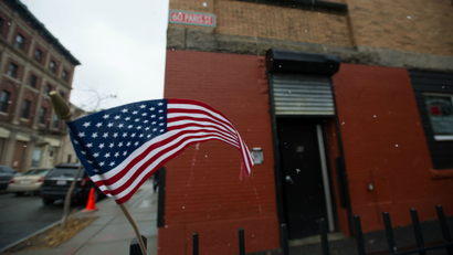 A flag waves in the wind before an AT&T holiday gifting event for wounded veterans in East Boston, Mass. Thursday, Dec. 11, 2014. (Gretchen Ertl/AP Images for AT&T)