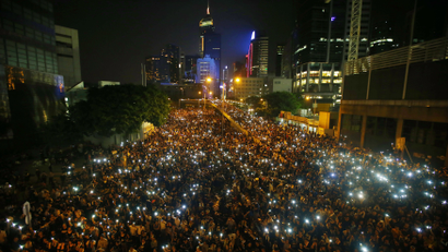 Protesters hold their mobile phones as they block the main street to the financial Central district, outside the government headquarters, in Hong Kong September 29, 2014.