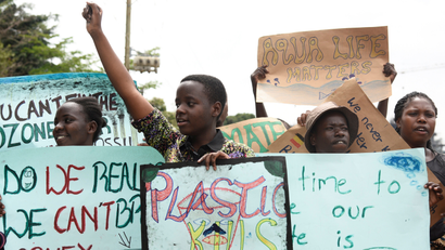 Leah Namugerwa carries a placard and gestures as she leads Ugandan students in taking part in the global 'School Strike for Climate' in Kampala