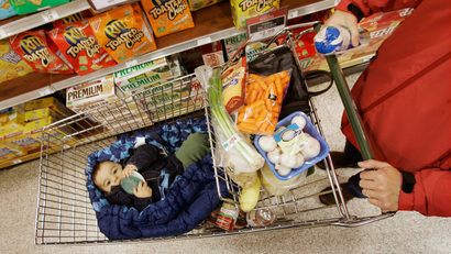 A shopper takes her son along for the ride which shopping at the Heinen's grocery store in Bainbridge Twp., Ohio in this Dec. 13, 2007 file photo. Steadily rising food costs aren't just causing grocery shoppers to do a double-take at the checkout line _ they're also changing the very ways we feed our families. (AP Photo/Amy Sancetta, file)