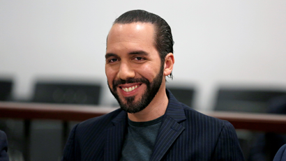El Salvador president Nayib Bukele smiling and wearing a black shirt and jacket