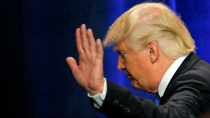 President-elect Donald Trump with his hand up and looking away