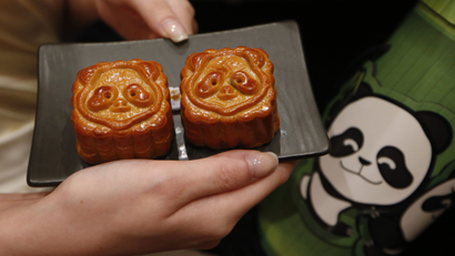 A staff member displays mooncakes glazed with Panda faces part of the celebration of the upcoming Mid-Autumn festival during a media preview of the Food, Tea and Chinese Medicine Fairs in Hong Kong, Wednesday Aug. 1, 2012. More than 1,400 exhibitors from all over the world are expected to participate in the fairs. (AP Photo/Kin Cheung)