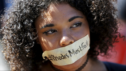 A student with a #RhodesMustFall sticker taped across her mouth.