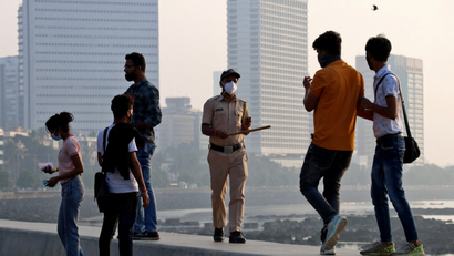 A policeman asks people to leave the promenade at Marine drive, in Mumbai