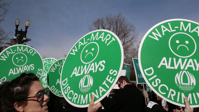 Women hold anti-walmart signs at supreme court case in 2011