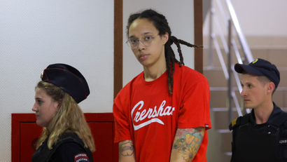 Brittney Griner being led to court in handcuffs by two officers in Russia
