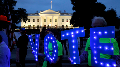 Protestors hold up letters spelling "VOTE" outside of the White House in Washington.