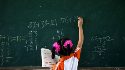 A girl writes on a chalkboard during a math class at Dongba Experimental School, a school for the children of migrant workers, in Beijing Thursday, Aug. 25, 2011. The school has received multiple warnings from the government that it will be demolished later this week if it doesn't close.