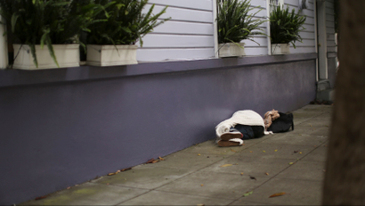 A person sleeps on a sidewalk in the Haight Ashbury neighborhood in San Francisco, California July 17, 2014. The median price for a single-family home or condominium rose to $1 million in June, according to a report released by DataQuick.