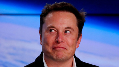 Close-up of Elon Musk in front of a blue background.