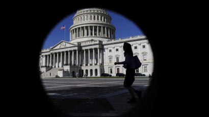 A woman walks past the US Capitol Building