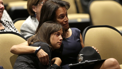 Susan Oliver, the wife of slain Sacramento County Deputy Danny Oliver, comforts their daughter, Jenny