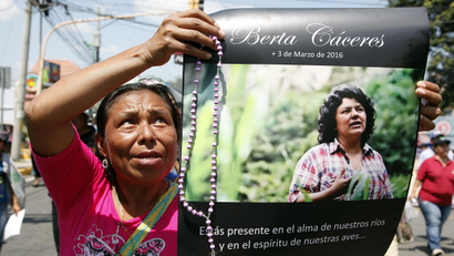 A woman holds up a poster with a photo of slain environmental leader Berta Caceres during a protest in Tegucigalpa, Honduras
