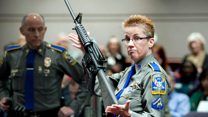 Firearms Training Unit Detective Barbara J. Mattson of the Connecticut State Police holds up a Bushmaster AR-15 rifle, the same make and model of gun used by Adam Lanza in the Sandy Hook School shooting, for a demonstration during a hearing of a legislative subcommittee reviewing gun laws, at the Legislative Office Building in Hartford, Conn., Monday, Jan. 28, 2013. The parents of children killed in the Newtown school shooting called for better enforcement of gun laws Monday at the legislative hearing.