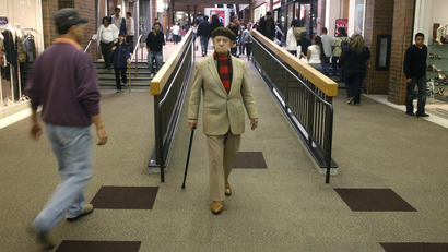 An elderly man walks with his cane amid shoppers at the Glendale Galleria shopping mall on Black Friday in Glendale, California November 28, 2008.