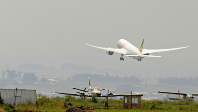 An Ethiopian Airlines plane takes off into a smoggy sky.