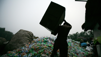In this photo taken Tuesday, Aug. 18, 2009, a man prepares to dump plastic bottles at a trash recycling center in Beijing, China. Garbage is piling up everywhere in China, posing problems for public health and people's livelihoods in a less savory measure of the country's rapid burst from poverty to prosperity. (AP Photo/Greg Baker
