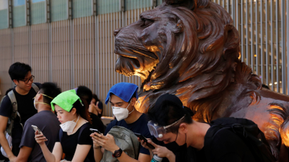 Protesters use their mobile phones as they stand outside HSBC bank headquarters during a demonstration against a proposed extradition bill in Hong Kong, China June 12, 2019.