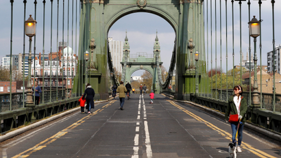 Pedestrians walk across Hammersmith Bridge following its' closure to traffic caused by critical faults in London