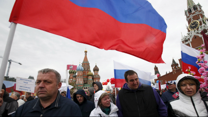 People walk with flags at Red Square during a 2015 May Day rally in Moscow.