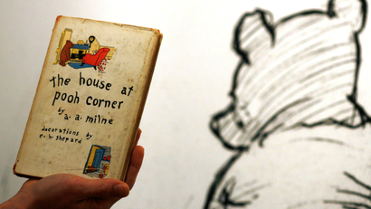 An employee poses with the first American edition of A.A. Milne's Winnie-the-Pooh book 'The House at Pooh Corner' dated 1928 at Sotheby's in London