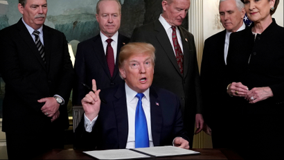 Donald Trump, surrounded by business leaders and administration officials, prepares to sign a memorandum on intellectual property tariffs
